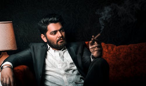 Man in a Black Suit Smoking a Cigar