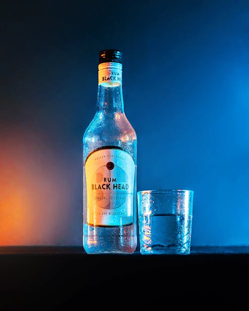 A Rum Black Head Beside a Clear Glass
