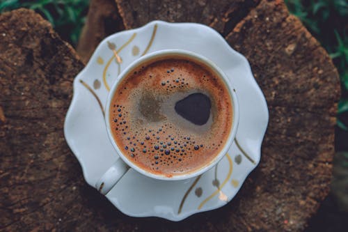 Free Cup of hot black coffee on tree trunk Stock Photo