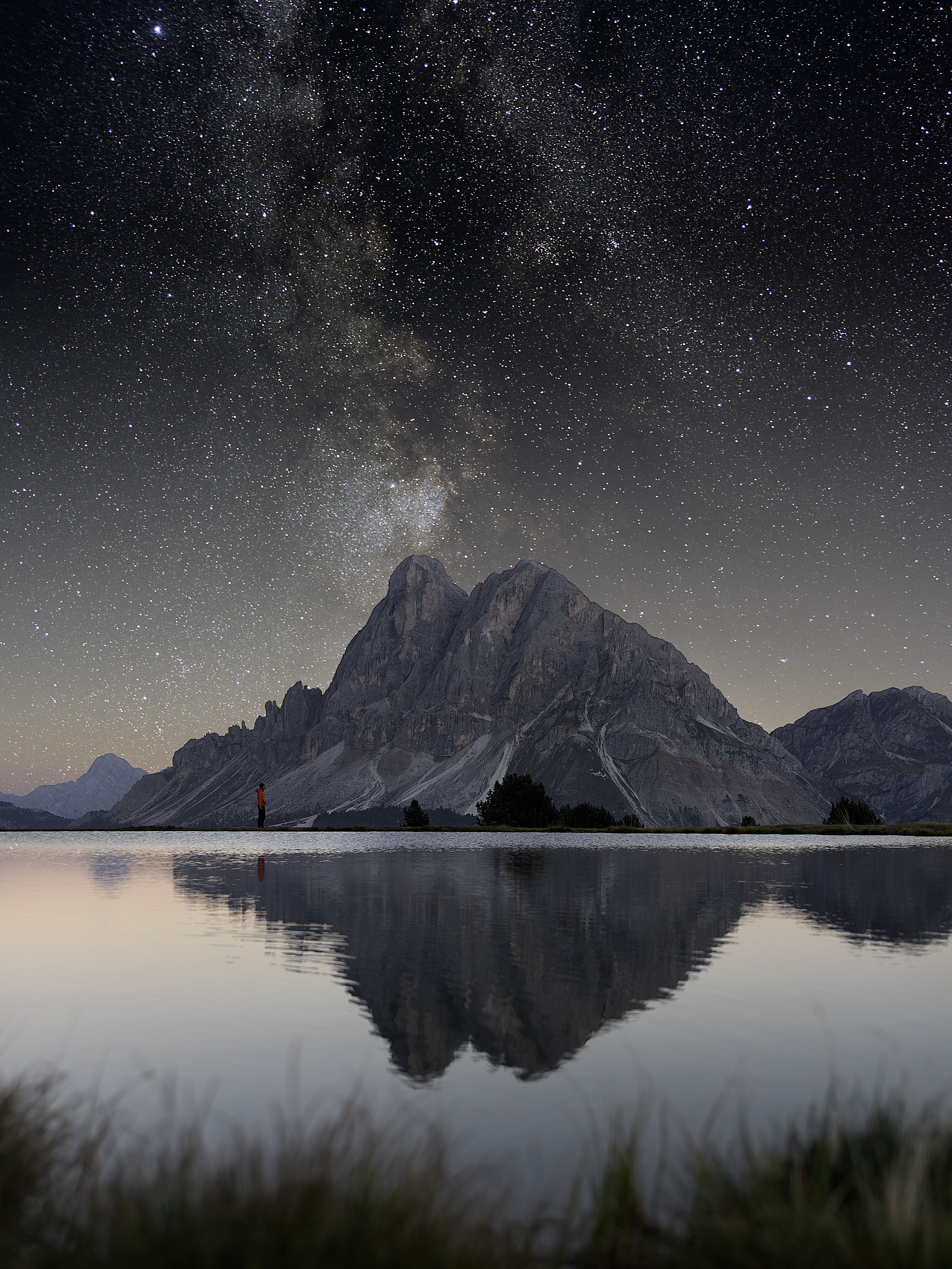 星光熠熠，天空下的湖面倒映着多洛米蒂山，景色令人惊叹