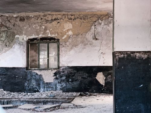 Free Grunge ruined concrete wall with chipped paints near crushed floor in desolated obsolete building Stock Photo