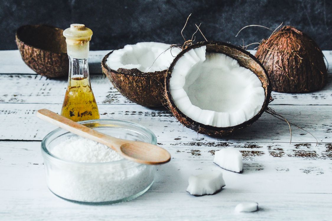 Natural coconut oil and coconuts on rustic table