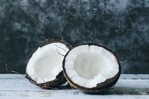 Free Halved coconut on rustic background, showcasing fresh and nutritious white flesh. Stock Photo