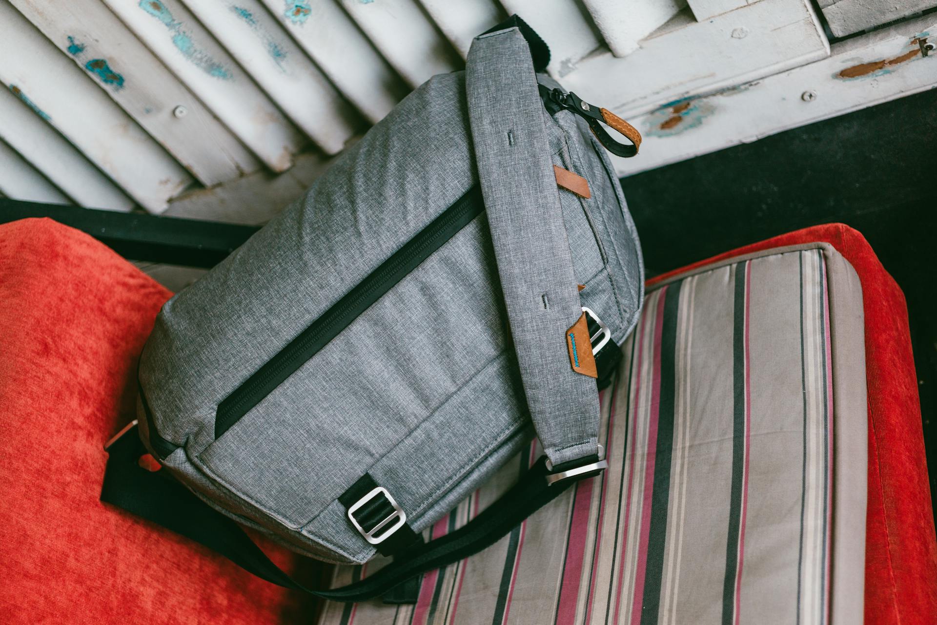 Gray travel bag on sofa near shabby door