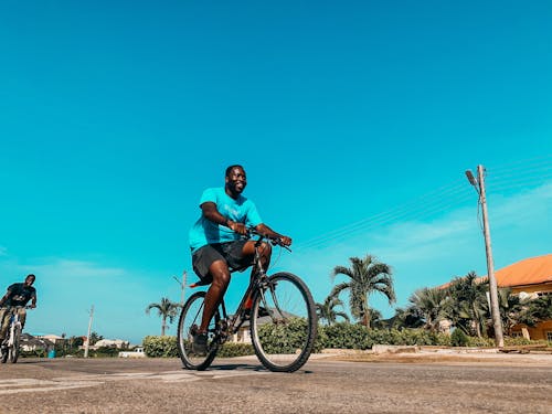 Free Man in Blue Shirt Riding a Bicycle Stock Photo