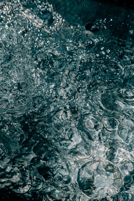 From above of ripples and bubbles on surface of clean water creating by raindrops