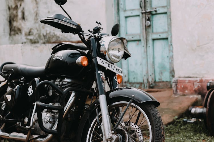 Black Royal Enfield Motorcycle Parked Near A House