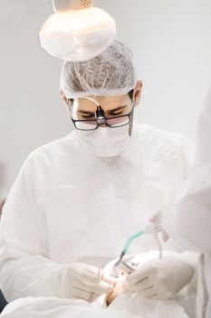 专业牙医正穿着防护装备进行牙科手术