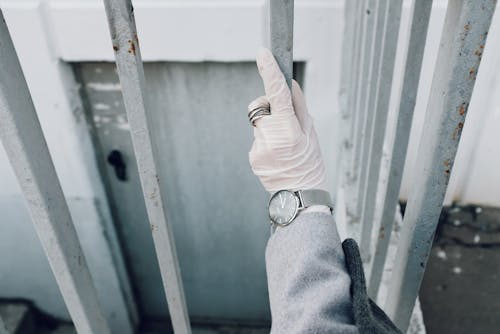 Free Person With Latex Gloves Holding a Fence Stock Photo