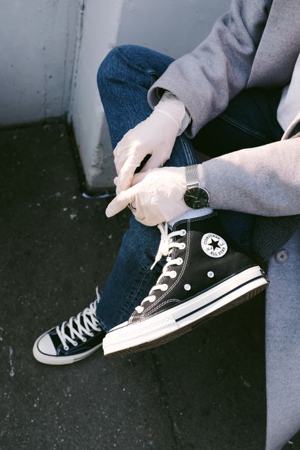 Casual style with sneakers, latex gloves, and watch highlighting modern fashion outdoors.