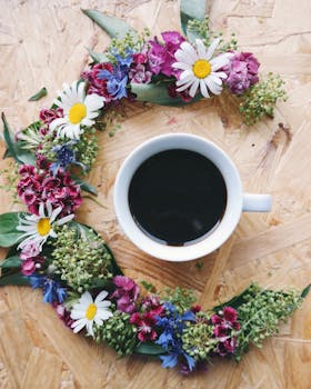 木桌上，一杯黑咖啡被鲜艳的花朵环绕着