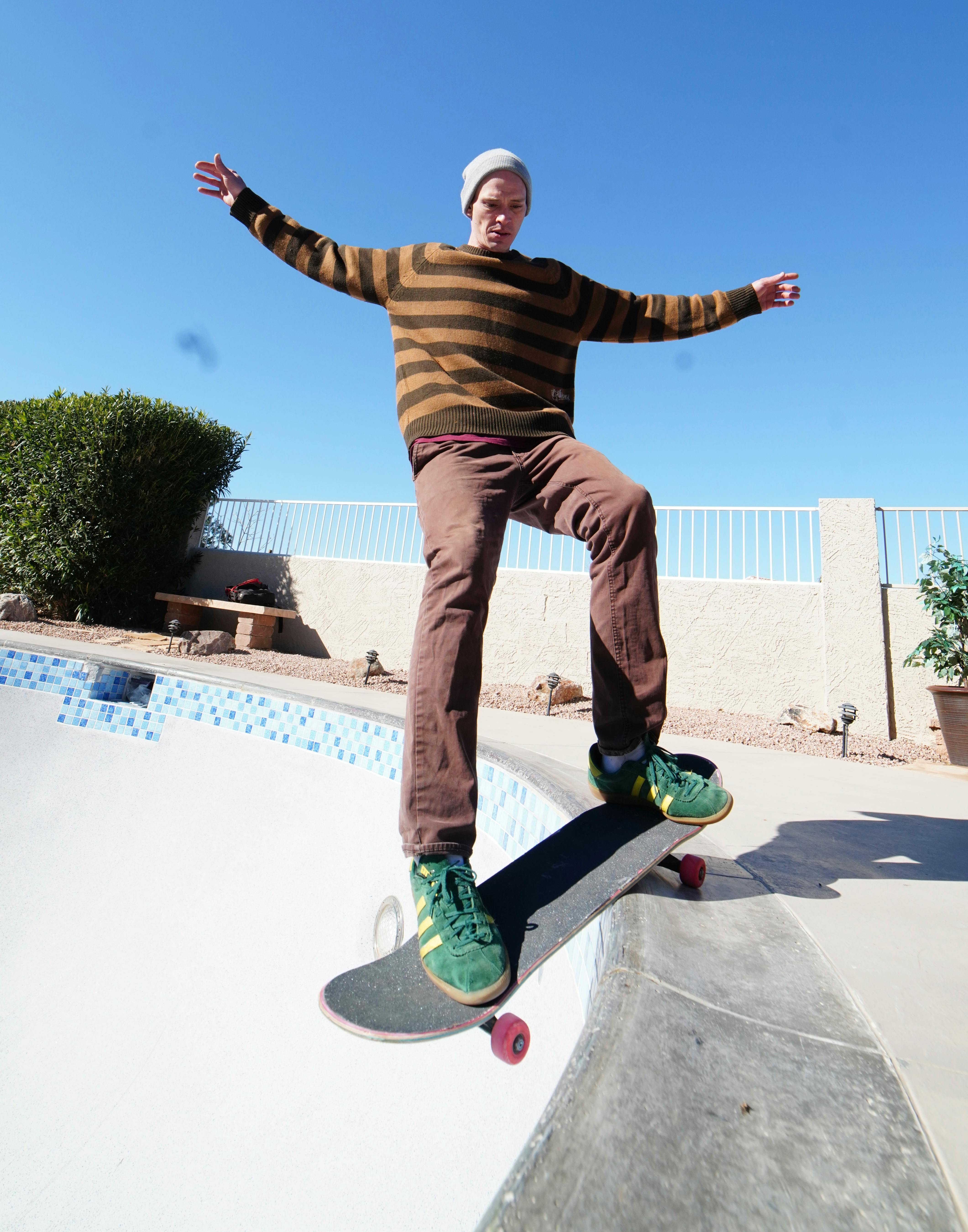 Active young man showing tricks on skateboard on ramp · Free Stock Photo