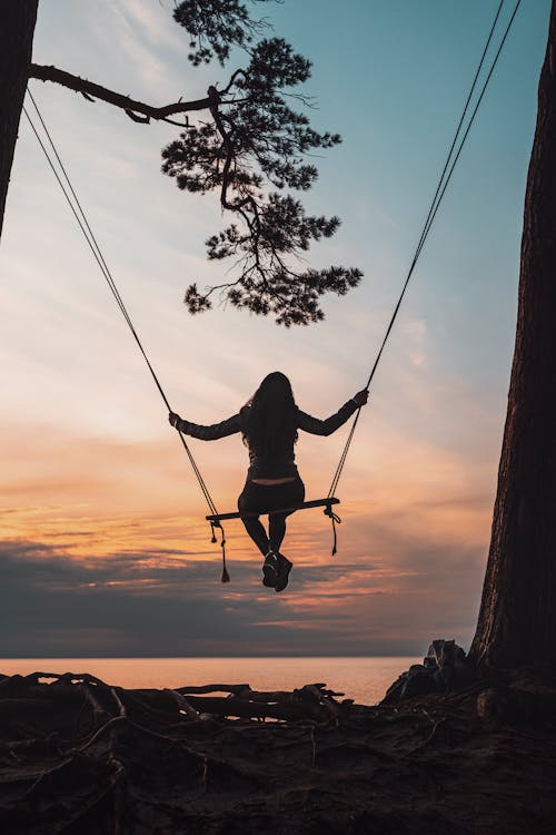 Free Silhouette of Person Sitting on Swing during Sunset Stock Photo