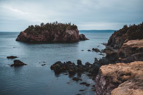 Free Amazing view from stony coast on sea with lonely cliff under stormy sky Stock Photo