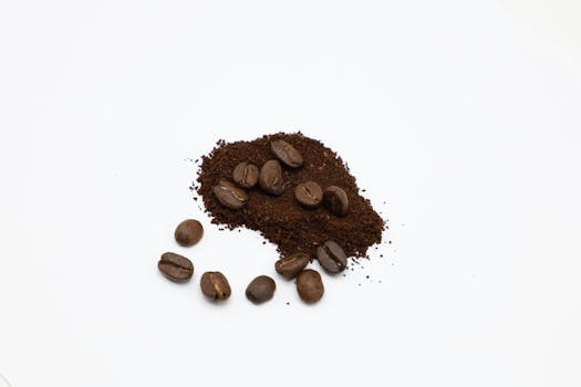 Roasted coffee beans and ground coffee on a white background, highlighting texture and freshness.