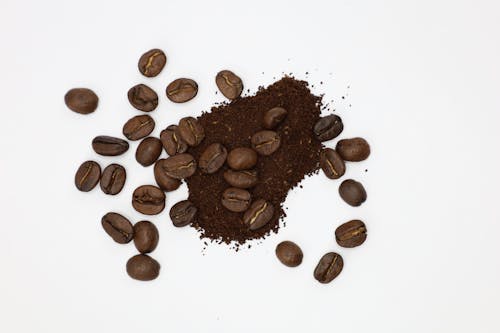 Close-Up Shot of Roasted Coffee Beans on White Surface