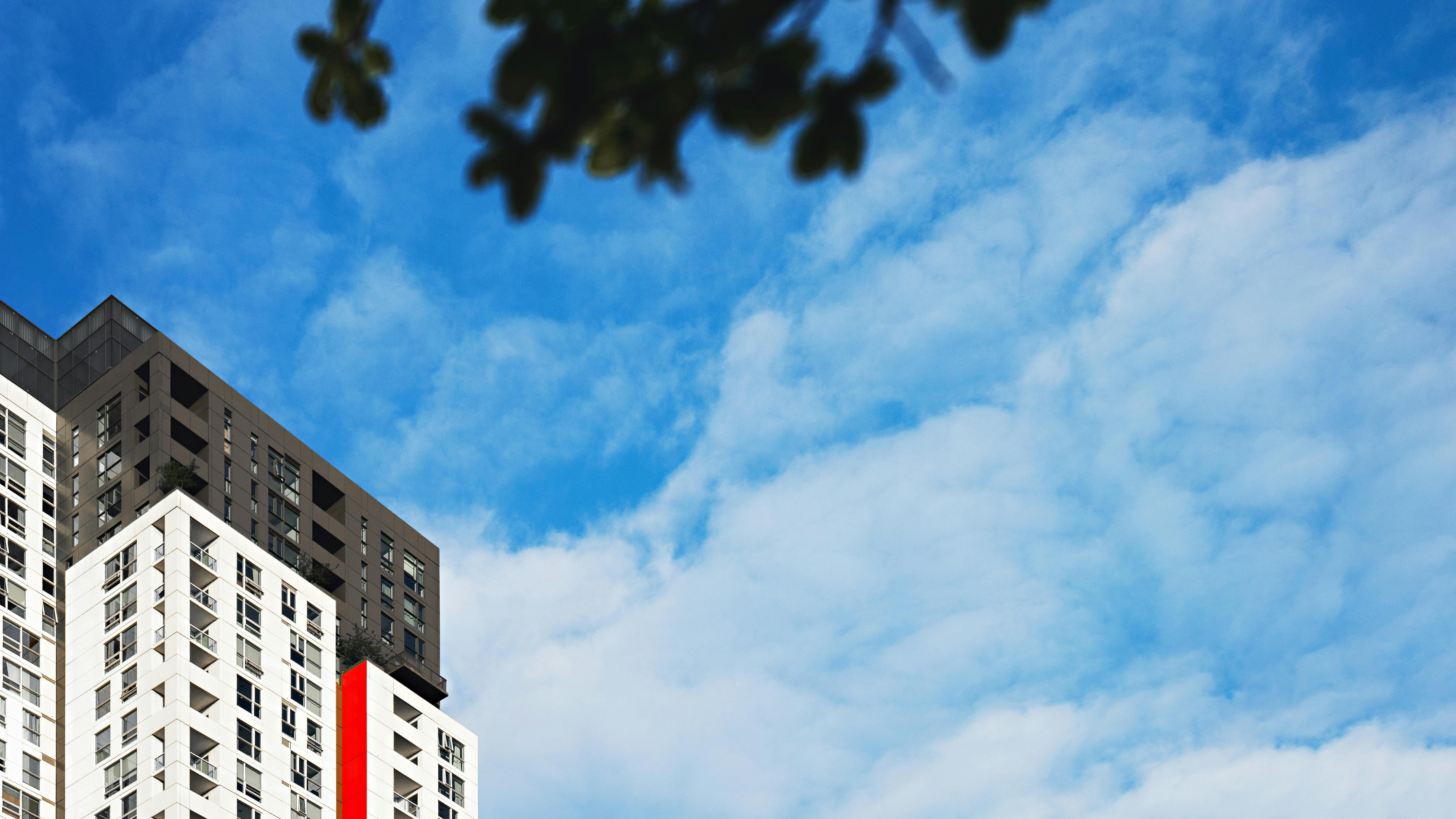 当代高层建筑，在充满活力的蓝天和缕缕云的映衬下，显得格外壮观