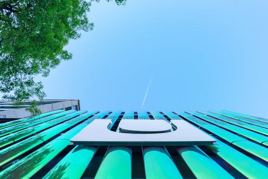 低角度视角下的现代建筑立面，反射着表面与清澈的蓝天