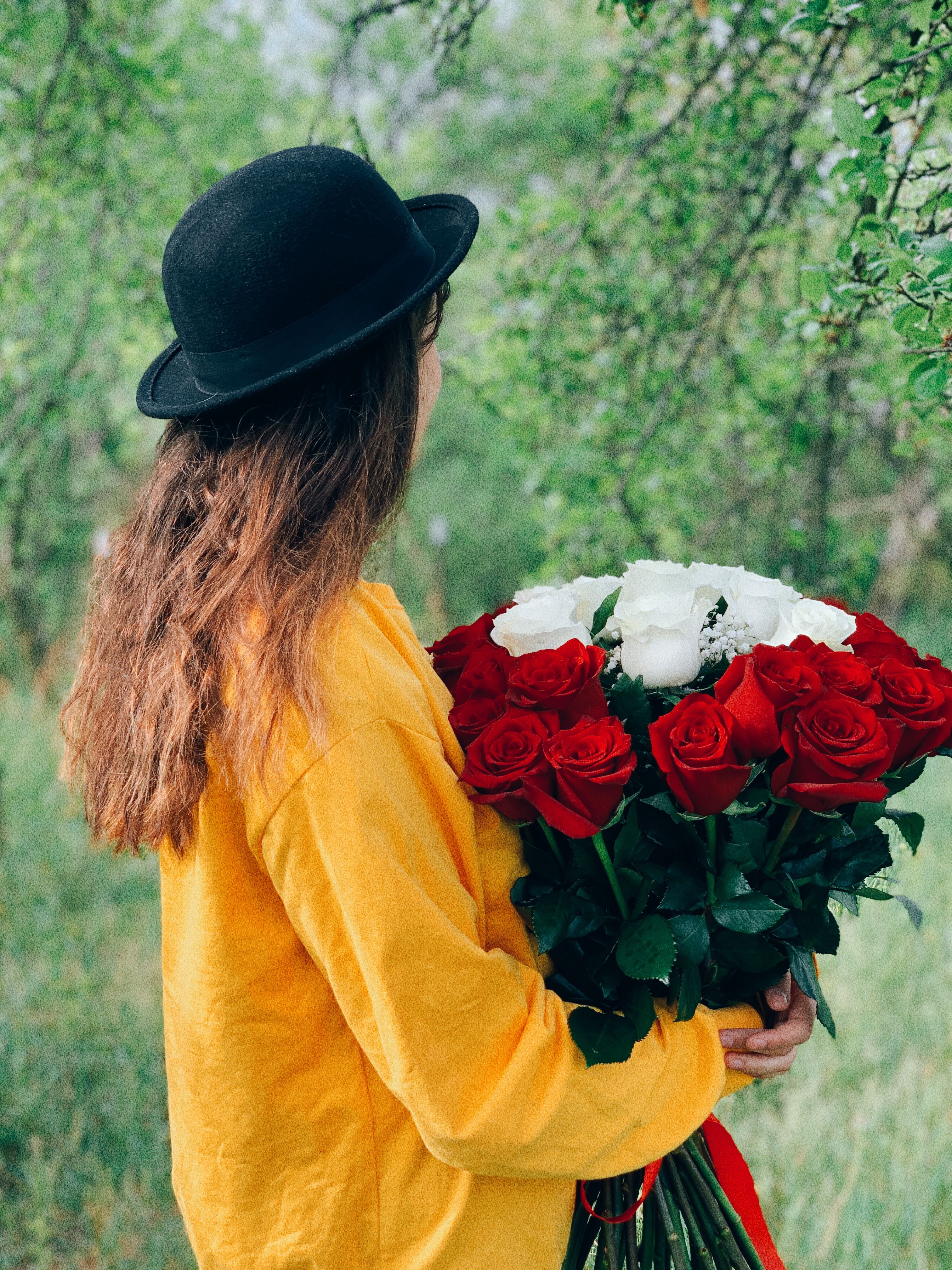 Young woman in hat with bouquet of flowers · Free Stock Photo
