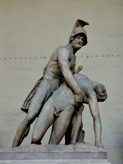 Aged marble statue of Menelaus supporting naked body of Patroclus on pedestal in Florence