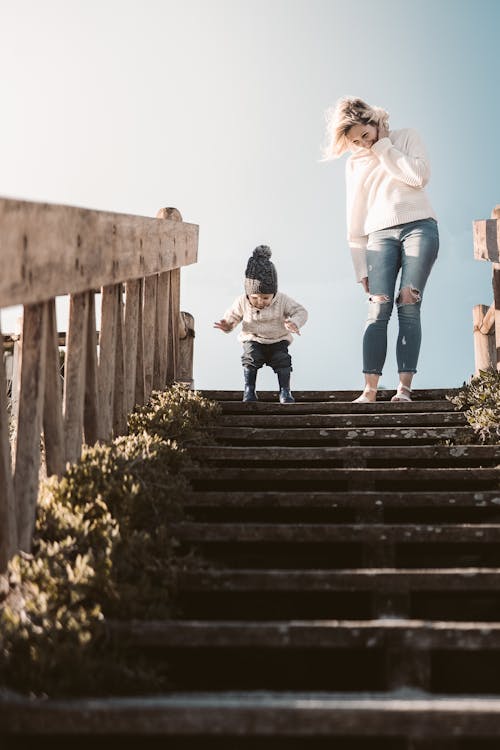 Free A Mother and Her Child Going Down the Stairs Stock Photo