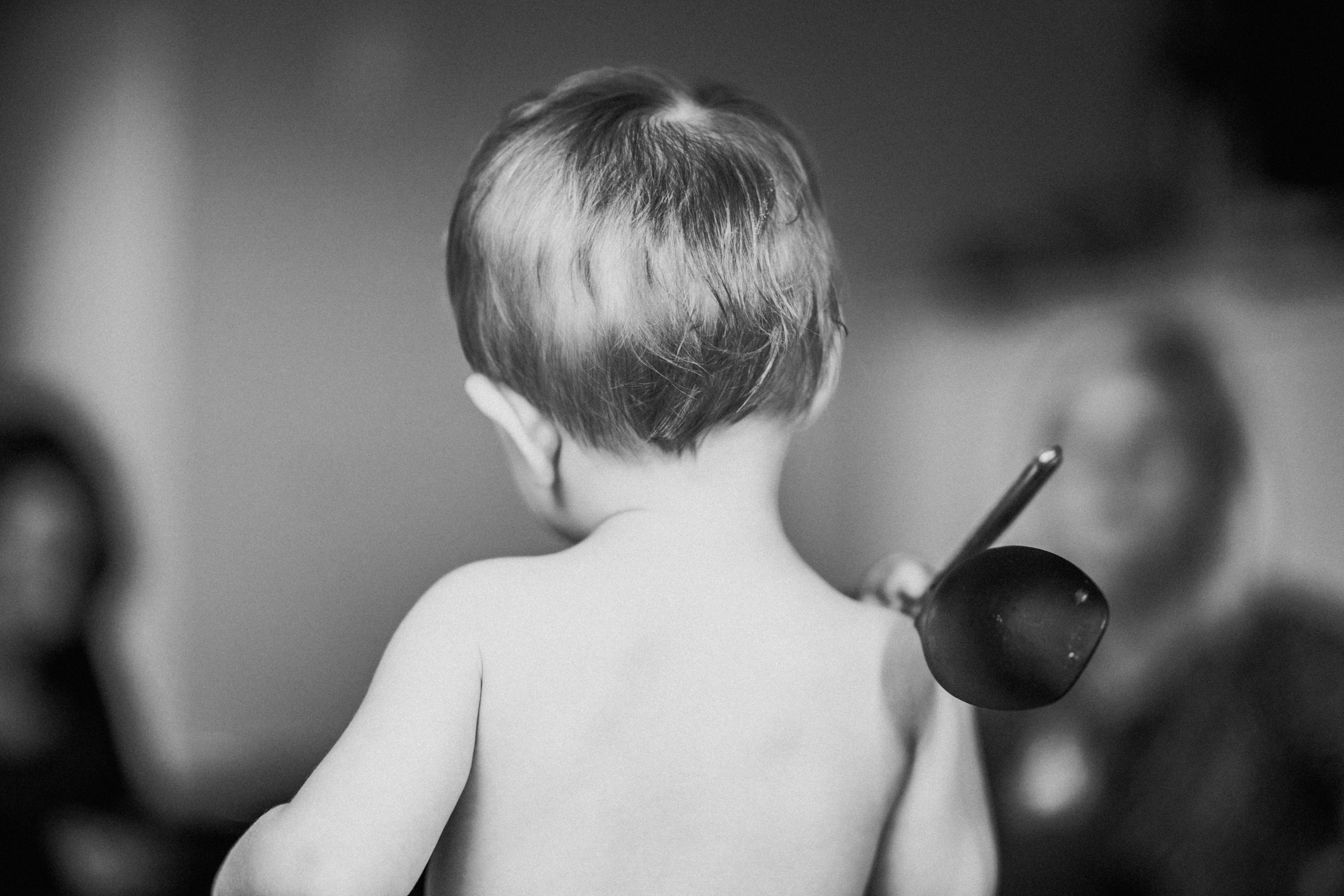 一名幼儿拿着勺子，在单色环境中创造出一个有趣的场景