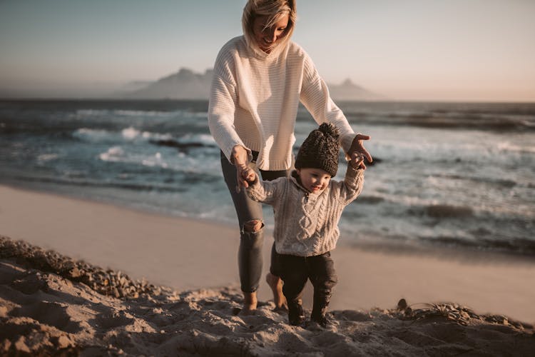 Mother And Her Child Walking On The Shore