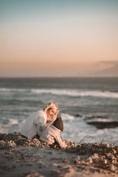 日落时分，母亲和孩子在海滩上共享了一段宁静的时光