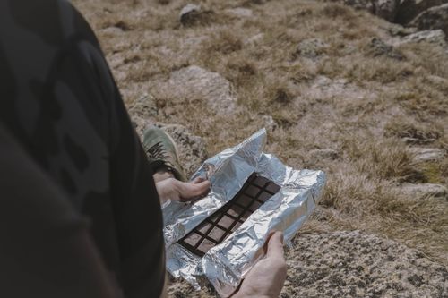 Free Person enjoying a chocolate bar while hiking in Kosciuszko National Park, Australia. Stock Photo
