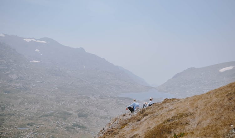 People Sitting On Top Of A Mountain