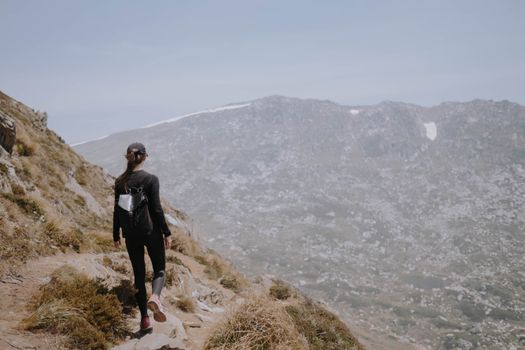 A woman hikes a scenic trail in Kosciuszko National Park, Australia.