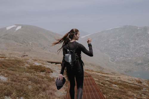 Woman in Black Leather Jacket Standing on Brown Wooden Dock