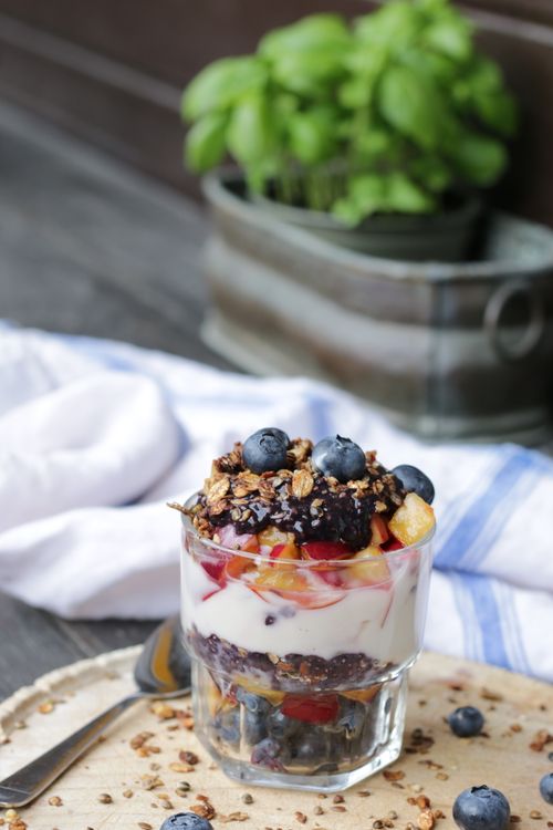 Free Healthy yogurt parfait with blueberries, granola, and peaches in a glass cup. Stock Photo