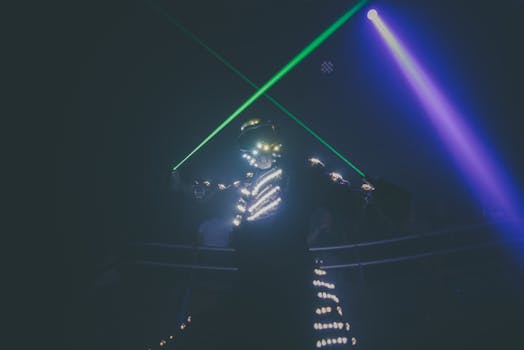 Futuristic dancer in illuminated suit performing under vibrant neon lights.