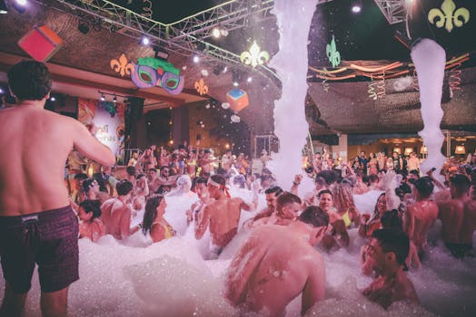 Energetic indoor foam party with a lively crowd enjoying the night in vibrant colors.