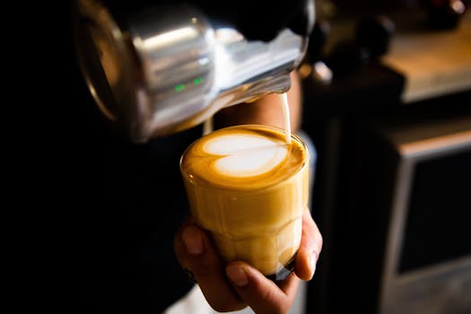 Close-up of barista creating heart-shaped latte art in a cozy Amman cafe.