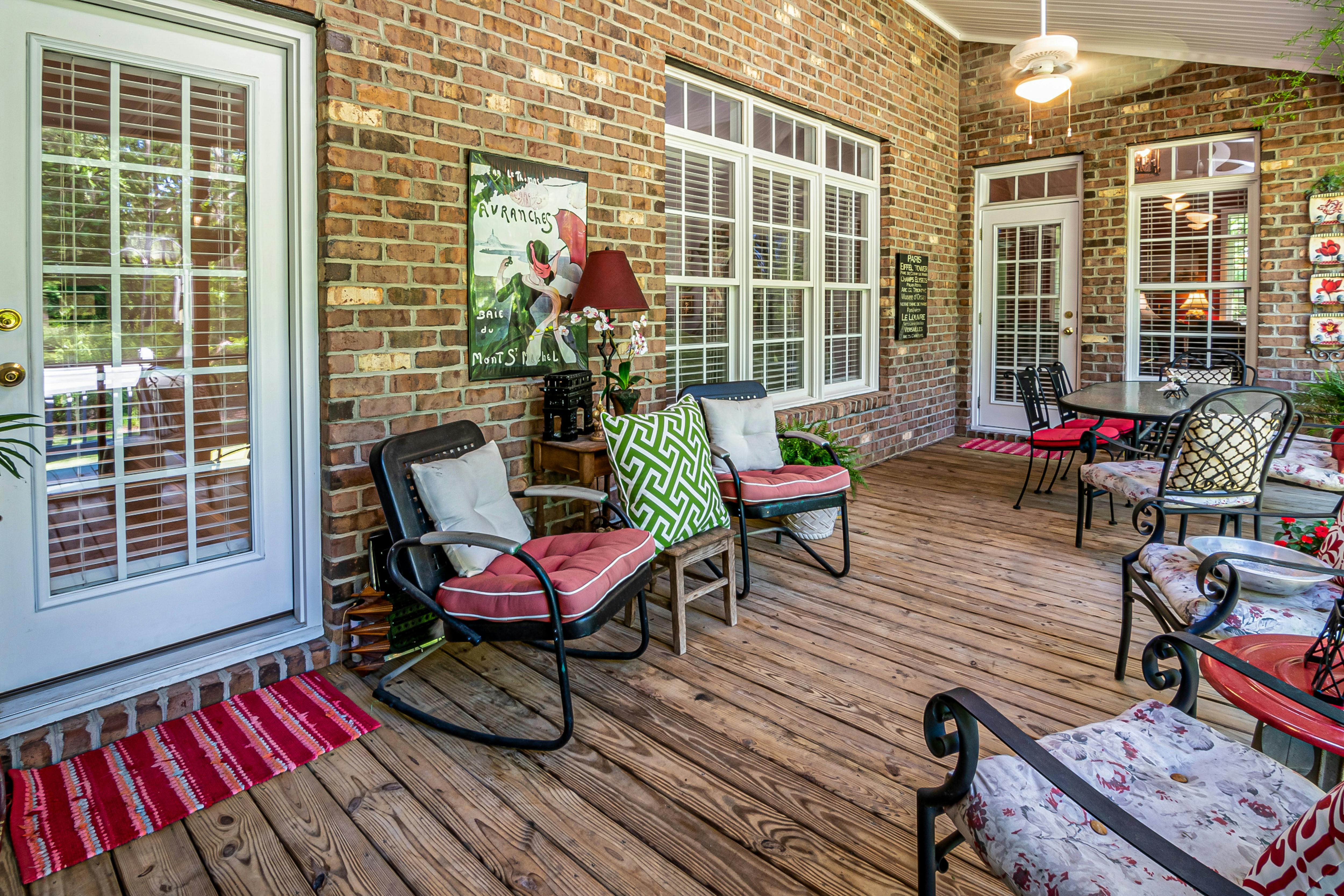 Charming brick patio featuring comfortable seating and natural wood floor for a relaxing ambiance.
