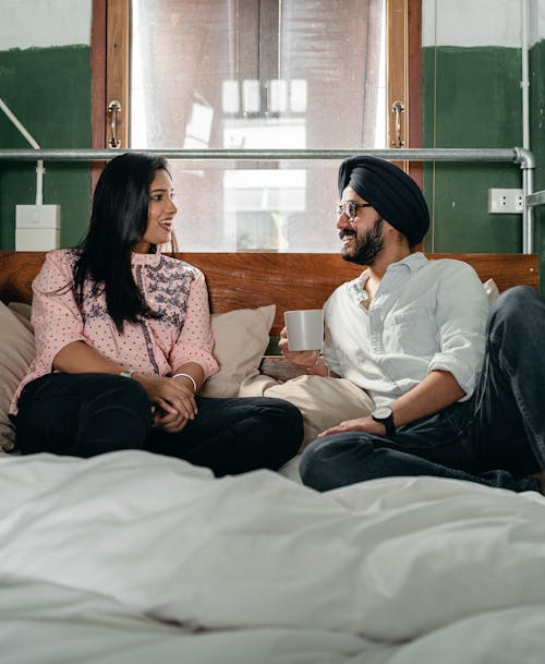 Happy couple chatting and lying on bed