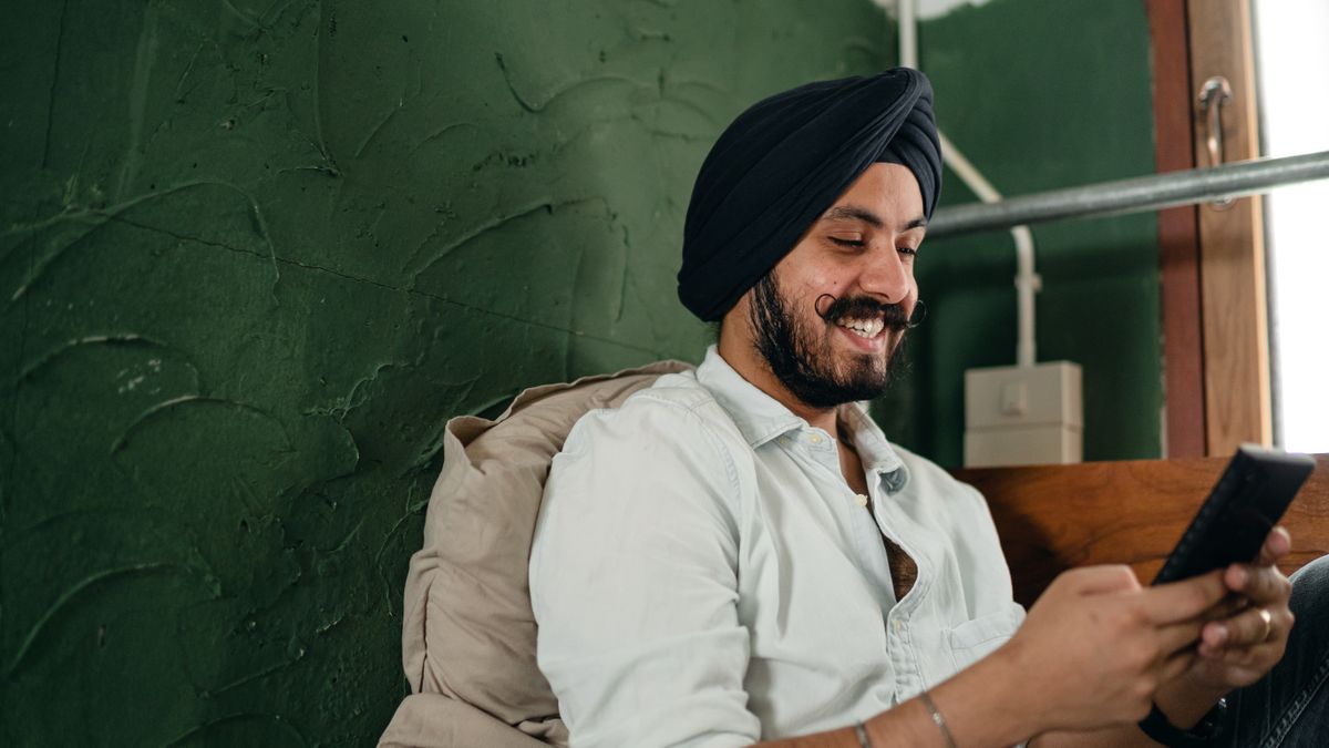 Man smiling while messaging on his phone