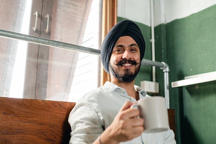 Happy Man With Coffee At Home Smiling At Camera