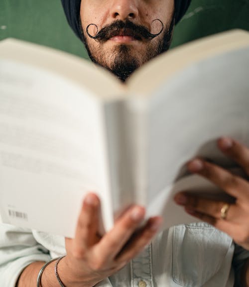 Free Crop man in casual shirt reading book Stock Photo