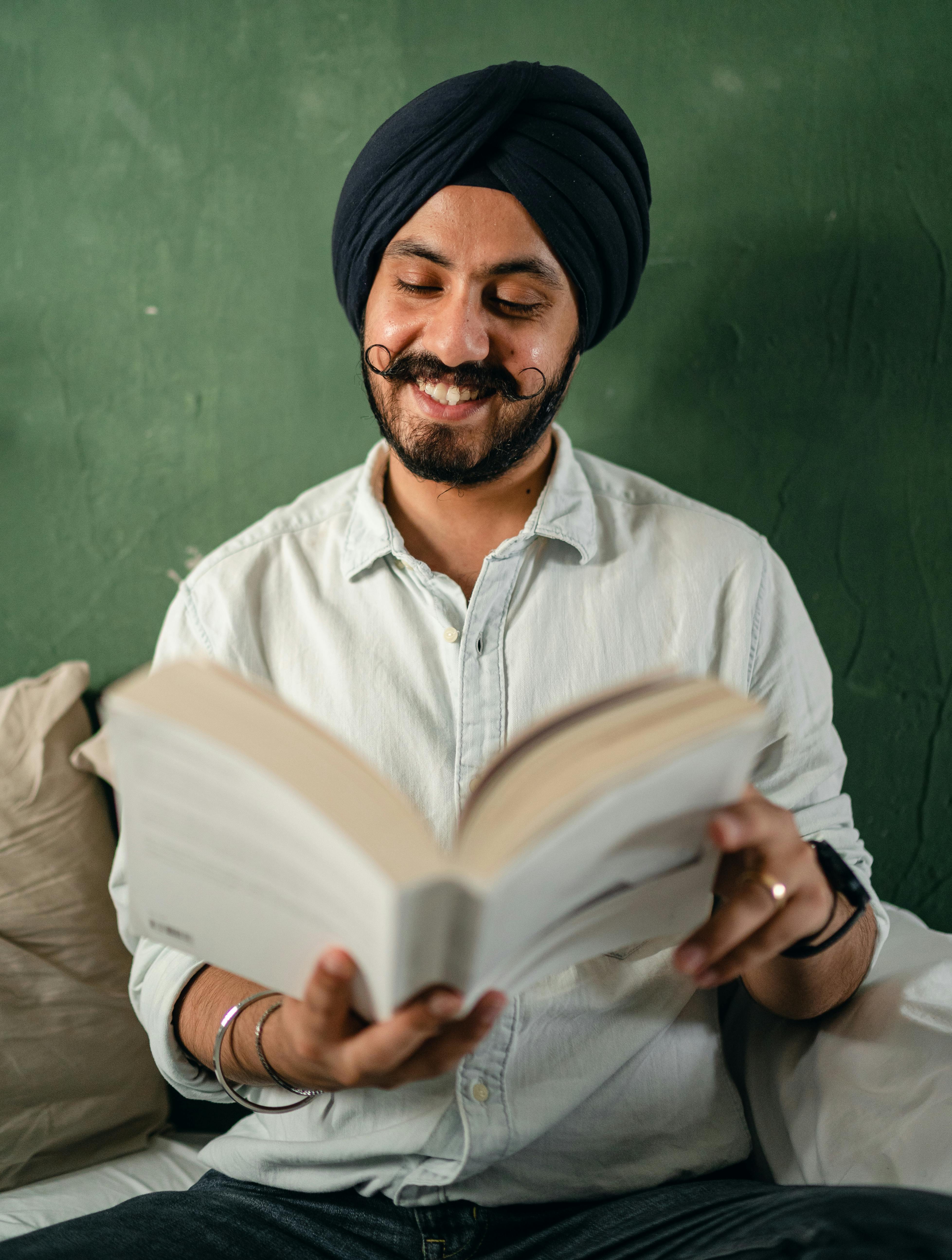 happy male reading funny book and smiling