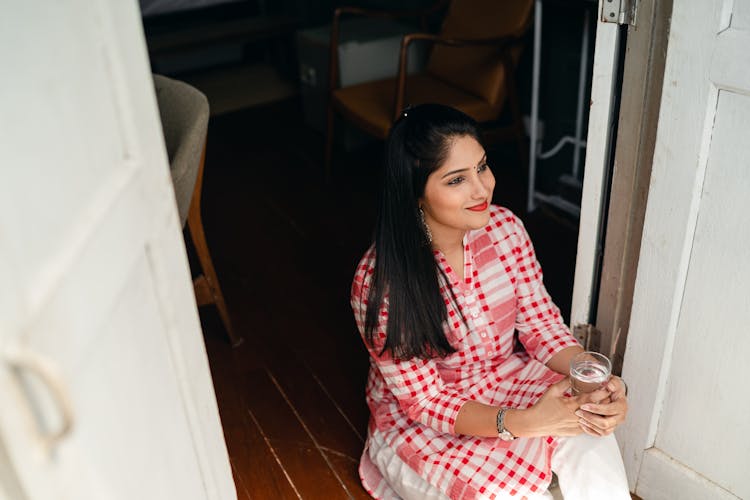 Happy Woman Drinking Water And Relaxing At Home