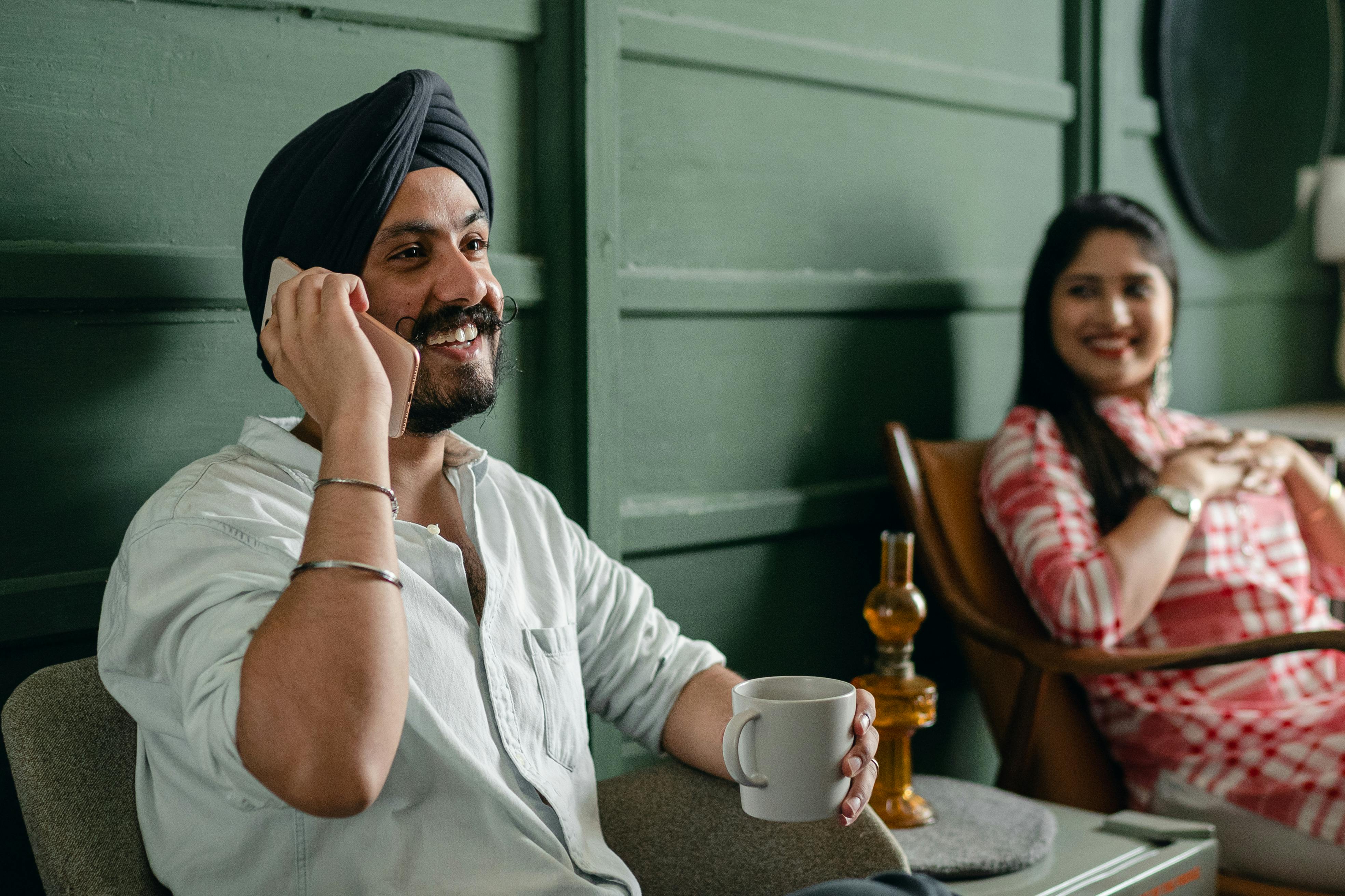 positive carefree man talking on smartphone and resting with girlfriend