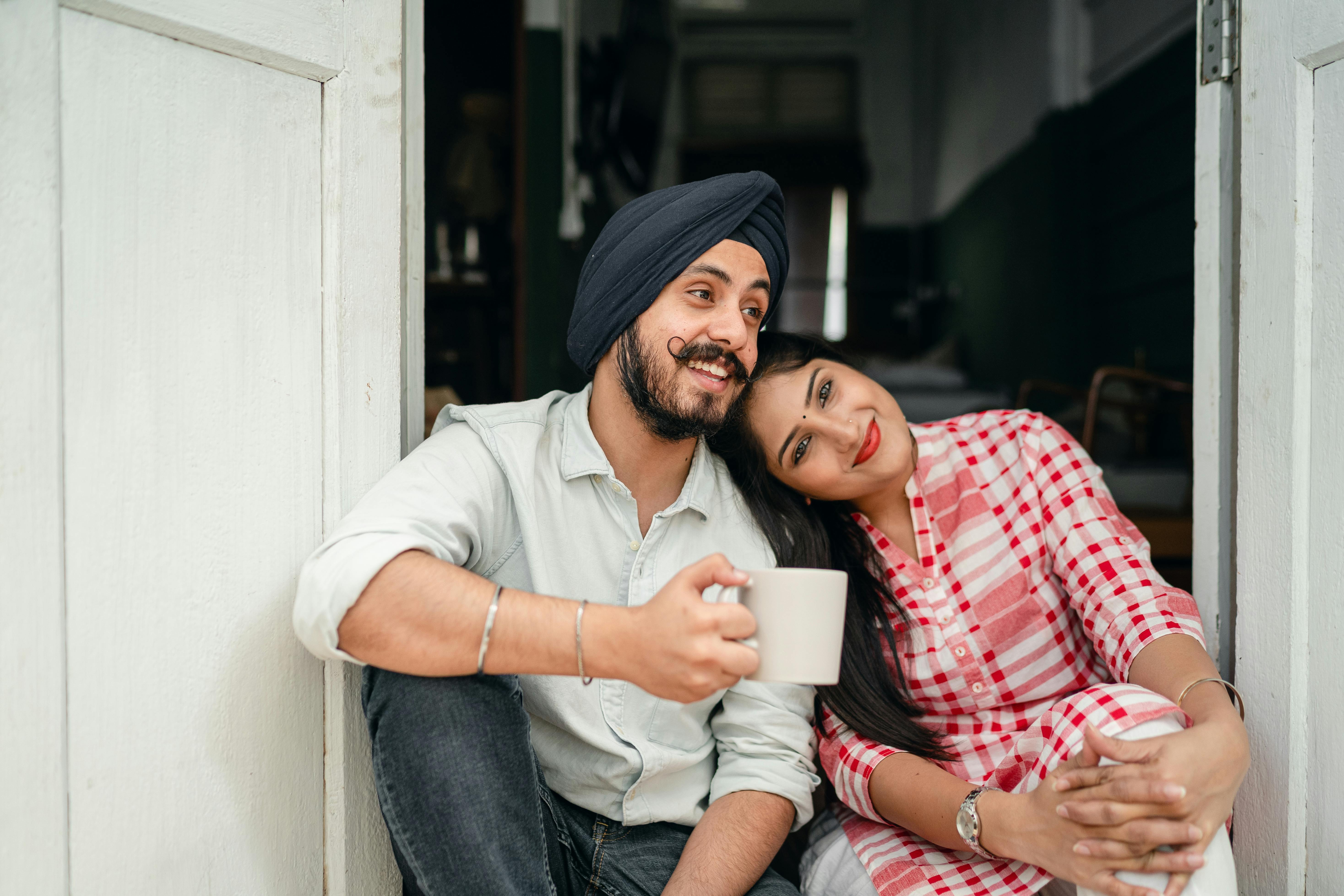 positive married couple relaxing on threshold of house