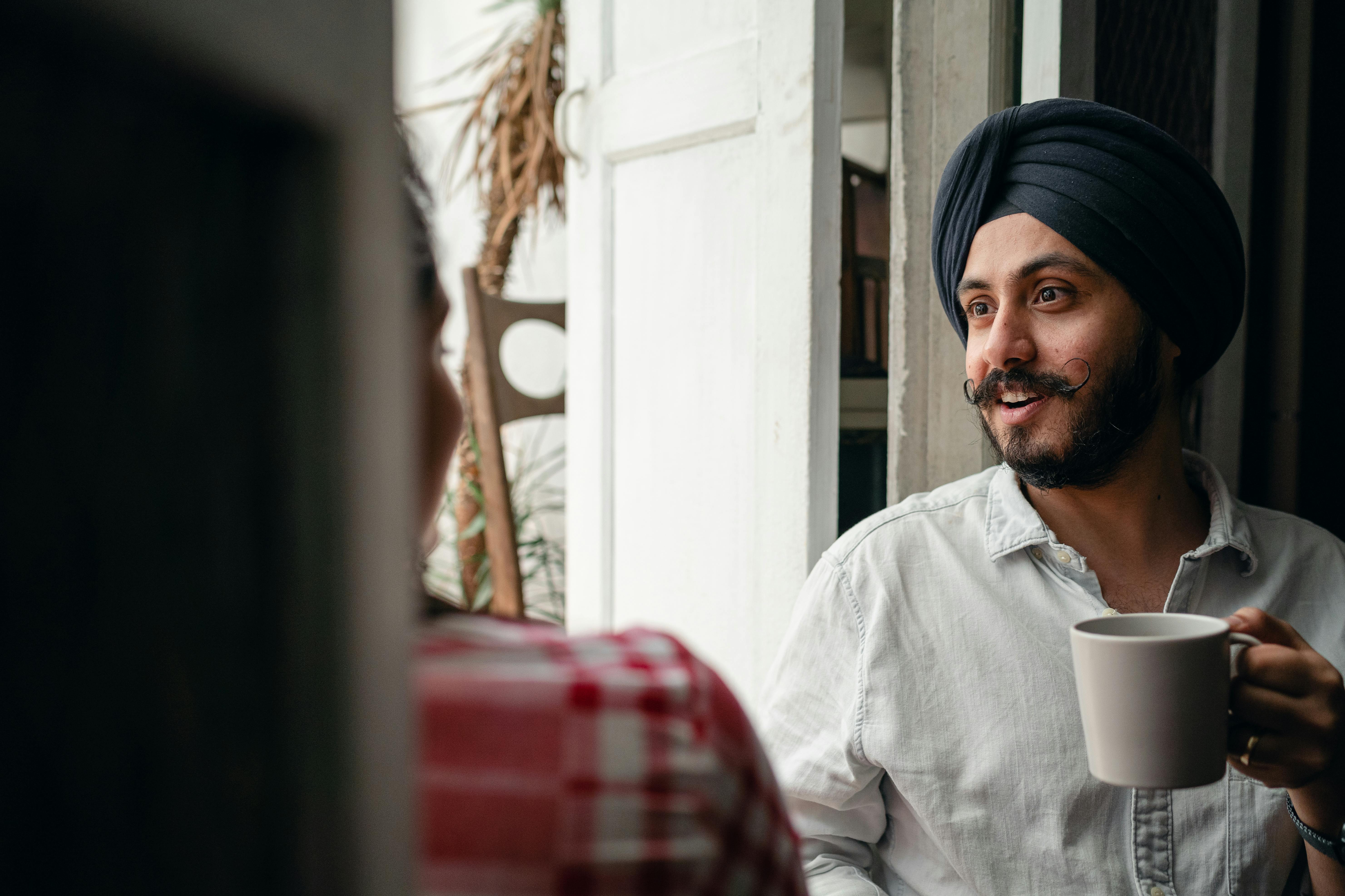 young man with coffee cup chatting with wife at home