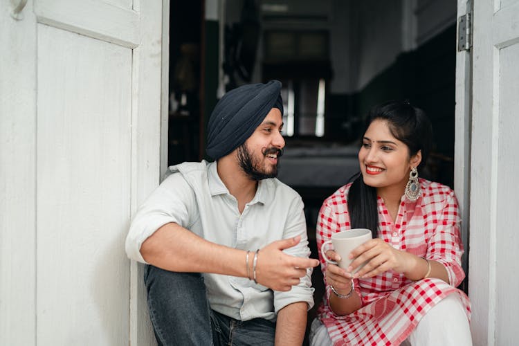 Smiling Couple Talking On Doorstep Of Cozy House