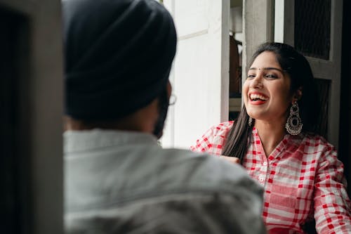 Free Trendy young woman laughing at joke told by man Stock Photo
