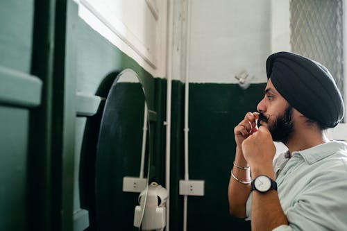 Stylish Sikh man taking care about beard and mustache