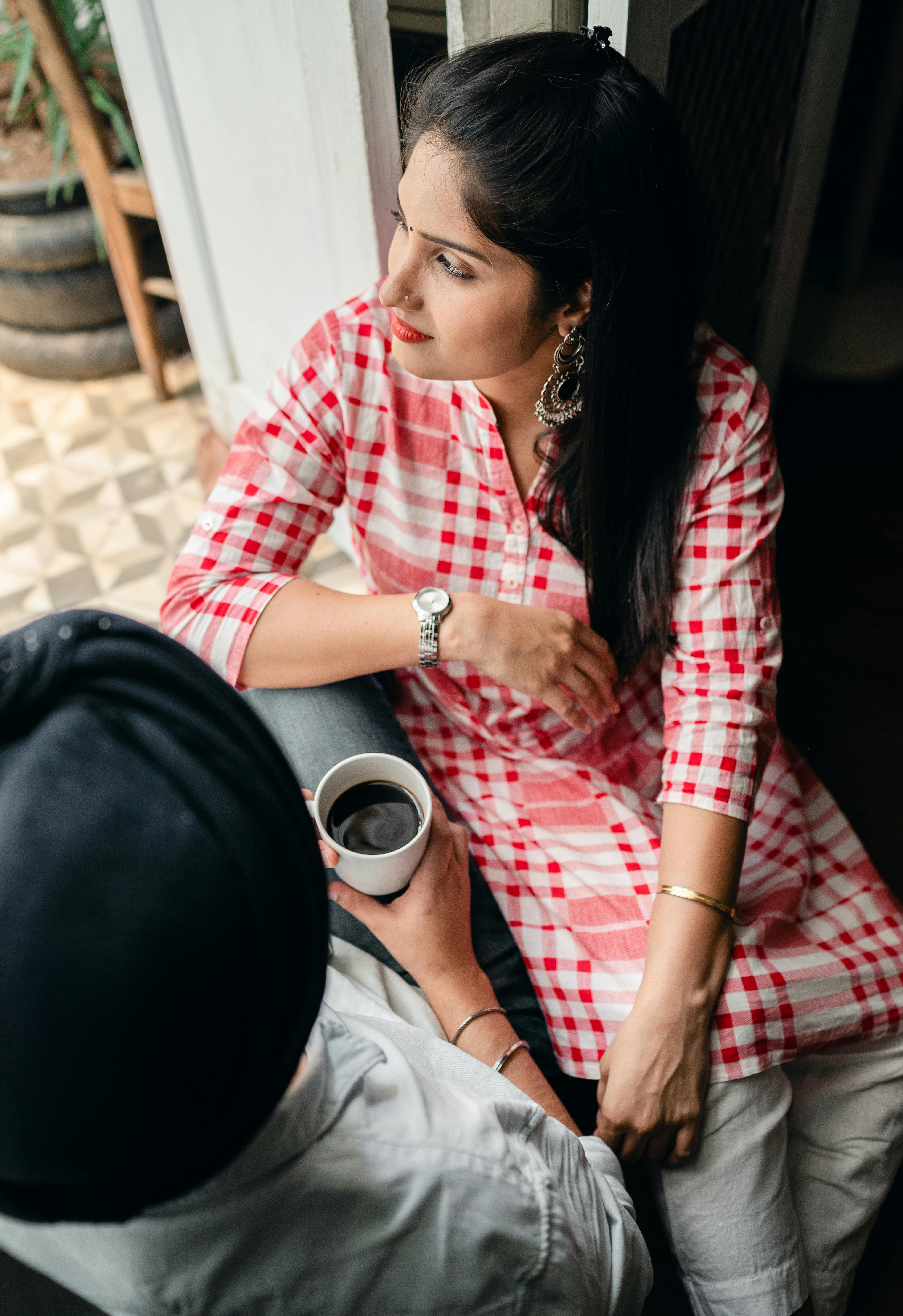 happy married indian couple drinking tea and having conversation at home